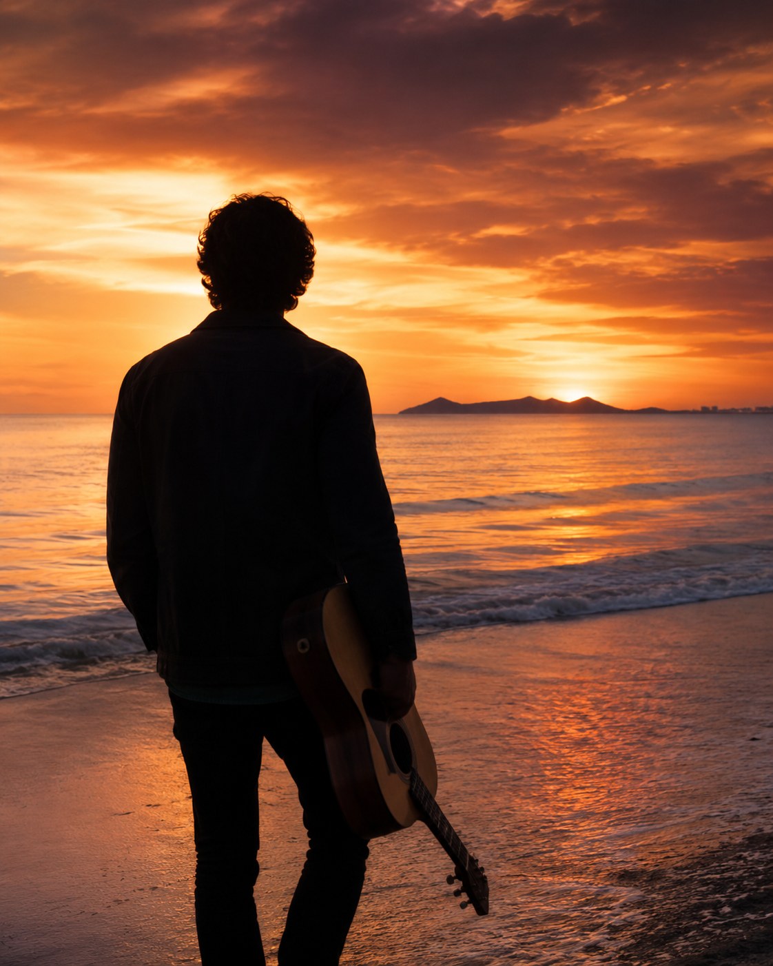 Silhouette of Daniel S. López from behind at the beach with guitar